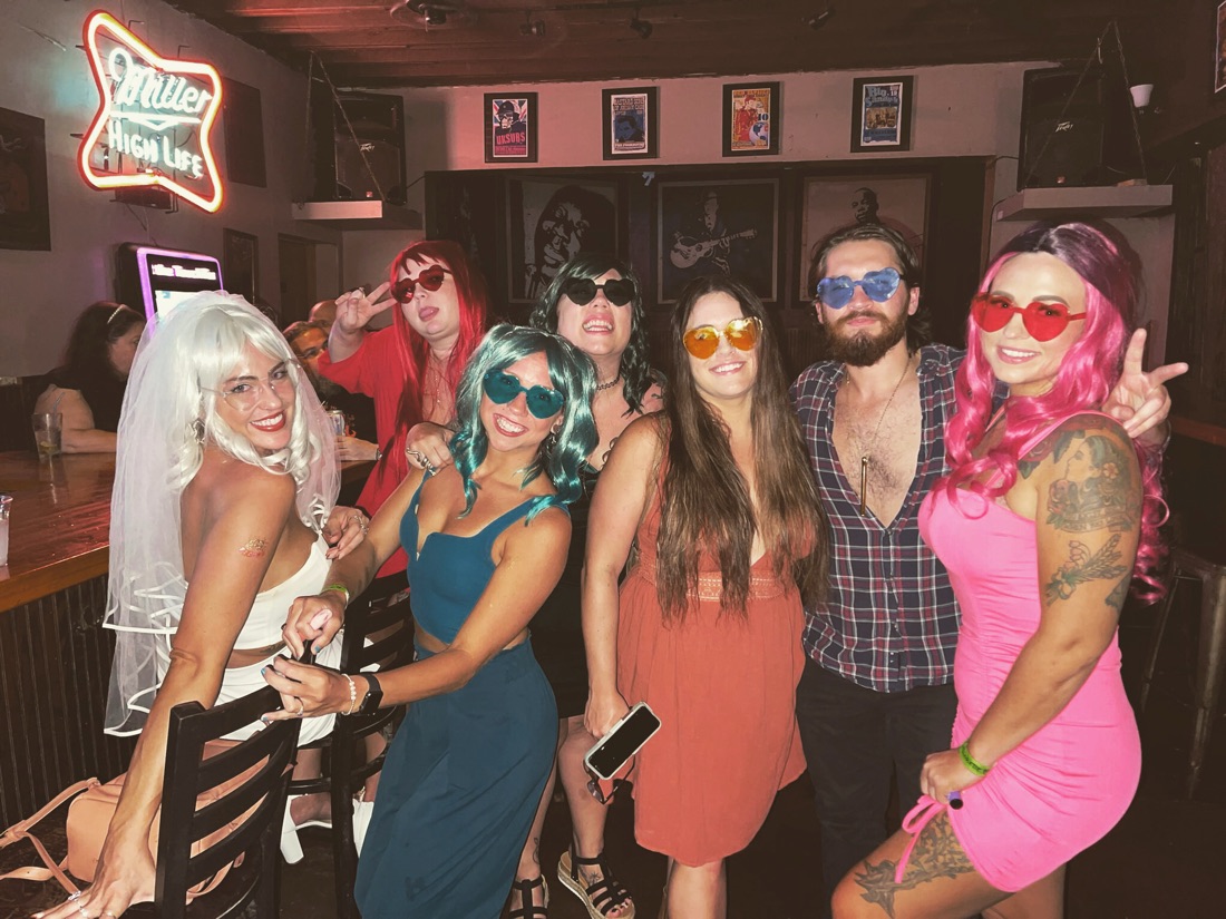 Matt with a big group of friends in costumes at a bar