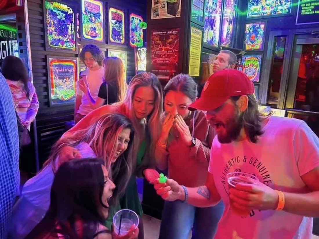 Matt with a group of friends laughing at a tiny rubber duck